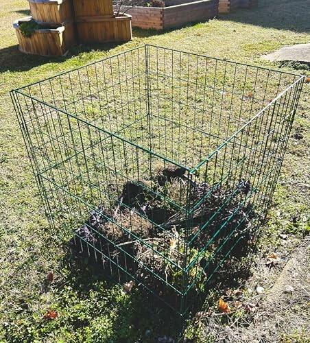 Wire compost bin on grass with soil and plants inside.