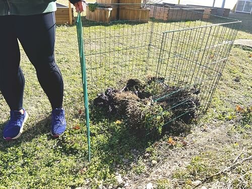 Person setting up a compost area with wire fencing.